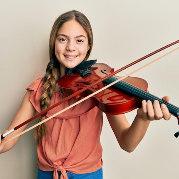 linda-menina-morena-tocando-violino-sorrindo-com-um-sorriso-feliz-e-legal-no-rosto-mostrando-os-dentes_839833-34748